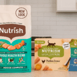 Bag of Rachael Ray Nutrish Indoor Complete dry cat food and Chicken Lovers wet food variety pack placed side by side on a bright kitchen counter with natural light.