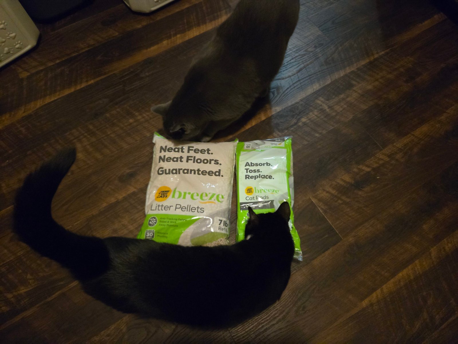 Breeze litter pellets and cat pads refill packs on a wood floor